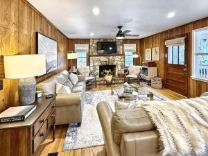 a living room with wood paneling and a fireplace at Highlands Hideout in Highlands