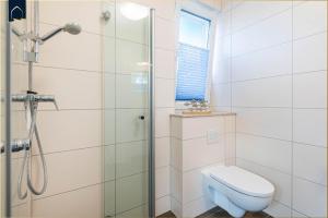 Un baño blanco con ducha y WC. en Kimpi 1, en Ostseebad Koserow 24 fotos más