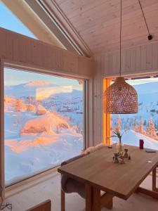 a room with a table and a large window with a view at Architect-Designed Cabin With Views Of Sigdal in Skadeland