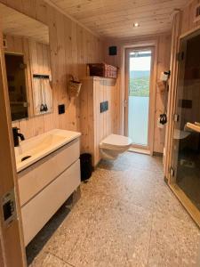 a bathroom with a tub and a toilet and a sink at Architect-Designed Cabin With Views Of Sigdal in Skadeland
