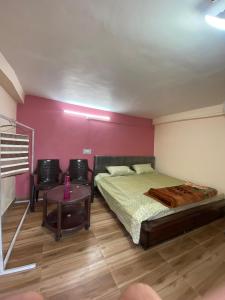 a bedroom with a bed and a table with chairs at Gautam Ashiyana Home stay in KumhÄrsain