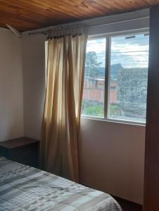 ein Schlafzimmer mit einem Bett und einem großen Fenster in der Unterkunft Apartamento a muy buen precio promoción 2x1 in El Tejar
