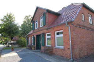 una casa di mattoni rossi con una panchina davanti di Kapitänshaus FW 2 EG re a Wustrow