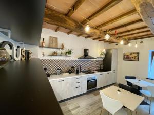a kitchen with white cabinets and a table and chairs at Il Gaudente B&B in Santa Fiora +65 photos