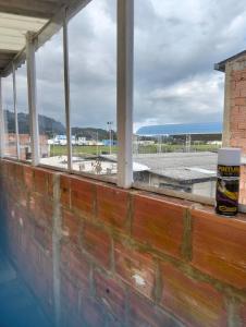 Eine Backsteinmauer mit einer Tasse Kaffee auf einem Fenster in der Unterkunft Apartamento a muy buen precio promoción 2x1 in El Tejar