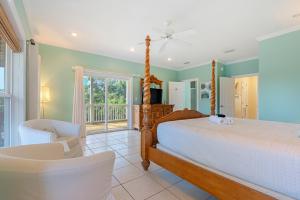 a bedroom with a bed and a chair and a window at Cape Palms in Port Saint Joe +32 photos