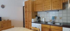 a kitchen with wooden cabinets and a sink at Apartment with terrace close to the slopes in Le Monêtier-les-Bains