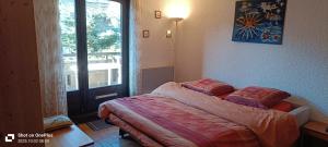 a small bedroom with a bed and a window at Apartment with terrace close to the slopes in Le Monêtier-les-Bains
