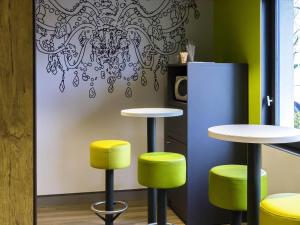 Habitación con 2 mesas y 2 taburetes en Ibis budget Lorient Caudan, en Caudan