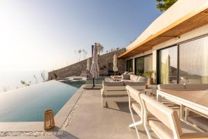 a house with a swimming pool with chairs and tables at Villa Lulu Lefkada in Kalamitsi