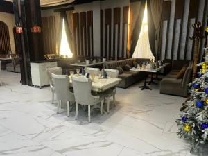 a restaurant with tables and chairs and a christmas tree at Parvina hotel and restaurant in Bukhara