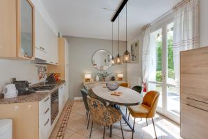 a kitchen with a table and chairs in a room at Villa Apartments - Porto Letizia in Porlezza