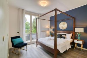 a bedroom with a canopy bed and a chair at Villa Apartments - Porto Letizia in Porlezza +206 photos