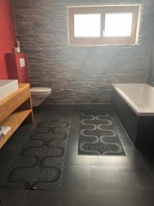 a bathroom with a tub and a toilet and a sink at Swissalpschalet Timber Inn 1st floor, 6 persons in Blatten bei Naters