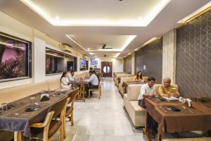 a group of people sitting at tables in a restaurant at FabExpress Seven Seas in Chinchiwad