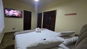 Un dormitorio con una cama y un televisor en la pared. en Refúgio nas Montanhas com Vista Deslumbrante, en Águas da Prata