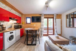a kitchen with red cabinets and a table in a room at Valloire Center in Valloire