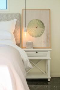 a bedroom with a bed and a table with a lamp at The Kina Cottage in Tutukaka +6 photos