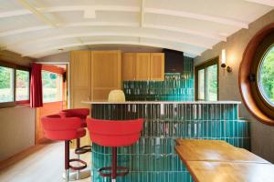 a kitchen with a bar with red chairs in it at Sterna boat & suites in Mechelen