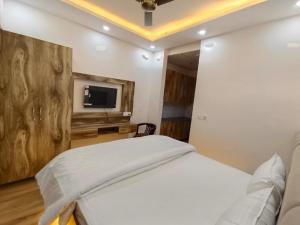 a bedroom with a bed and a flat screen tv at Anantya Inn in Greater Noida