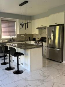 a kitchen with a stainless steel refrigerator and bar stools at One Bet room for 2Bet in Whitby