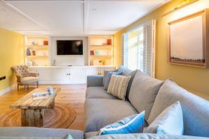 a living room with a couch and a table at Waterhen Cottage in Docking