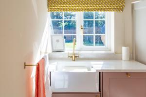 a kitchen with a sink and a window at Waterhen Cottage in Docking +25 photos