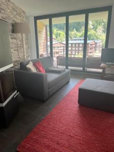 a living room with a couch and a red rug at Swissalpschalet Timber Inn 1st floor, 6 persons in Blatten bei Naters