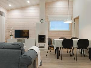 索特Villa Lakia的配有桌椅和电视的客厅