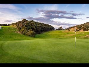 a view of a golf course with a green field at Boutique Coastal Retreat with Bath Walk to Beach in Mangawhai