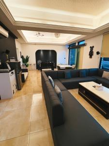 a living room with a couch and a piano at 恆春夏居心澍包棟民宿 10至20人入住 烤肉電動麻將水池Ktv in Hengchun