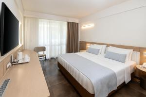 a hotel room with a bed and a flat screen tv at Thalassa Beach Resort & Spa (Adults Only) in Agia Marina Nea Kydonias