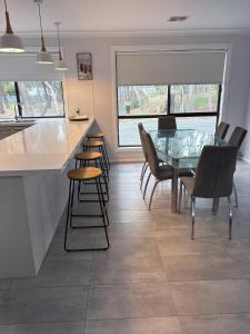 a kitchen and dining room with a glass table and chairs at New House in Beaufort in Beaufort