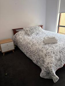 a bedroom with a bed with a comforter on it at New House in Beaufort in Beaufort