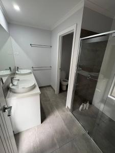 a bathroom with a toilet and a sink and a shower at New House in Beaufort in Beaufort +10 photos