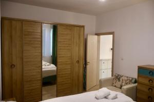 a bedroom with a large wooden closet and a bed at Casa Centrale with Free Parking in Plovdiv