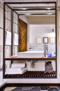 specchio in bagno con lavandino e asciugamani di Hotel Criol a Querétaro