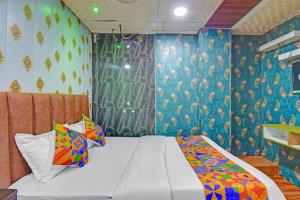 - une chambre avec un lit aux motifs colorés dans l'établissement FabExpress Arya Inn, à Pune