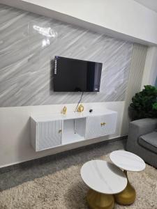 a living room with a tv on a wall at Hami Ventures in Kisumu