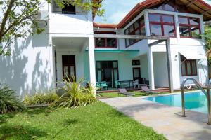 une maison avec une piscine devant dans l'établissement Harris Villa, à Hikkaduwa