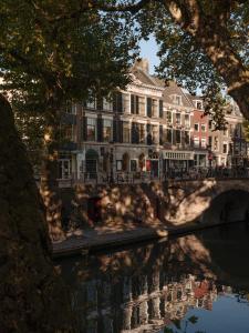 a building next to a river with a bridge at Conscious Hotel Oudegracht in Utrecht