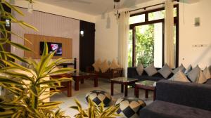 un salon avec un canapé et une table dans l'établissement Harris Villa, à Hikkaduwa