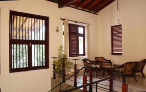 Cette chambre dispose d'un escalier avec des chaises et des fenêtres. dans l'établissement Harris Villa, à Hikkaduwa