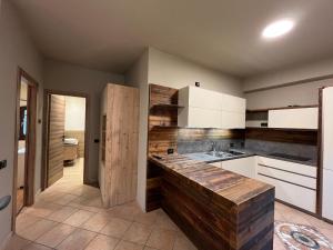 Una cocina con gabinetes blancos y encimera. en Bait da Nicolin - Myholidaylivigno, en Livigno 155 fotos más