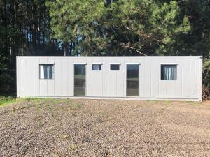 a white garage with windows on top of a field at Kitnet Nova e Aconchegante in Cachoeira do Sul +3 photos