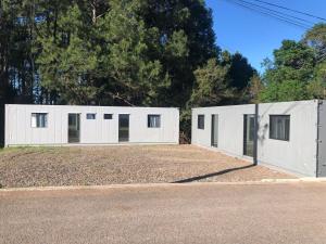 a pair of white storage buildings on the side of a road at Kitnet Nova e Aconchegante in Cachoeira do Sul