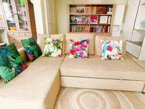 a couch with pillows on it in a living room at Charming riverside Independent Cottage with garden near Paris and Disneyland in Le Perreux-Sur-Marne