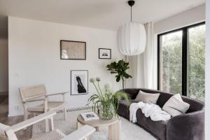 Newly built Scandinavian villa in Gothenburg في Hällsvik: غرفة معيشة مع أريكة سوداء وطاولة +14 صورة