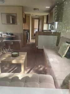 a living room with a couch and a table at Homely 8 Berth Caravan At Southview Park In Skegness Ref 33144S in Skegness