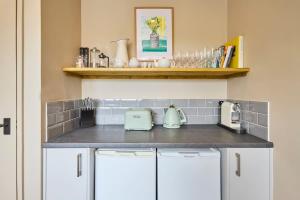 a kitchen with white cabinets and a counter top at The Beach House in Overstrand